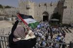 Bab el-Amoud. Palestinian woman raises a flag during the annual Jewish Flag March